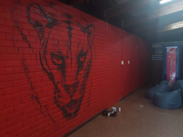 A painting of the Jaguar mural while being painted.